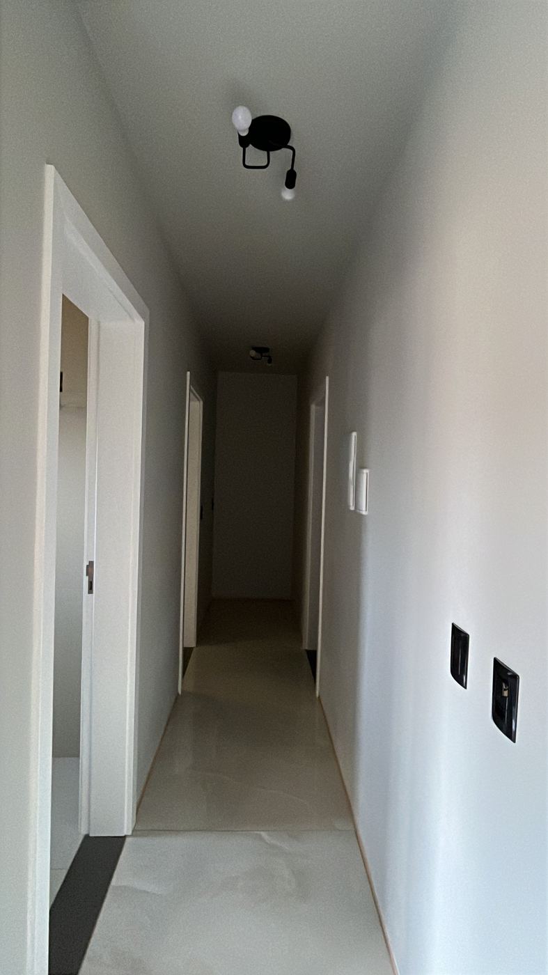 Corredor com iluminação e portas brancas
