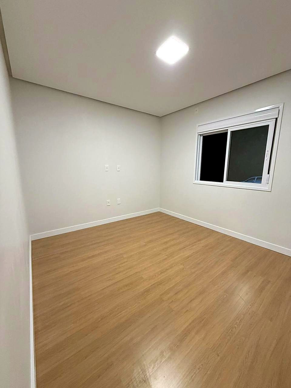 Quarto com piso laminado, rodapé e painel de LED